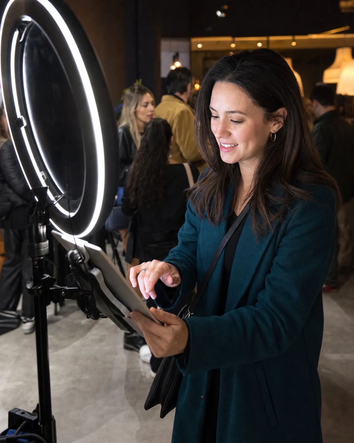 A shopper at a retail event tapping an iPad photo station on a ring-light stand to enter her contact details and receive her photo.